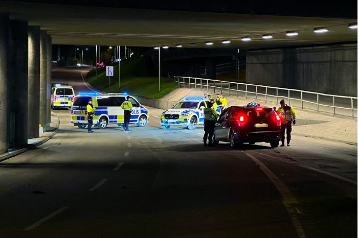 Foto från trafikinsatsen med poliser och polisbilar som spärrar av en väg under en tunnel.