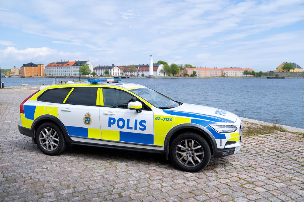 Polisbil parkerad vid kajkant med Stumholmen i bakgrunden.