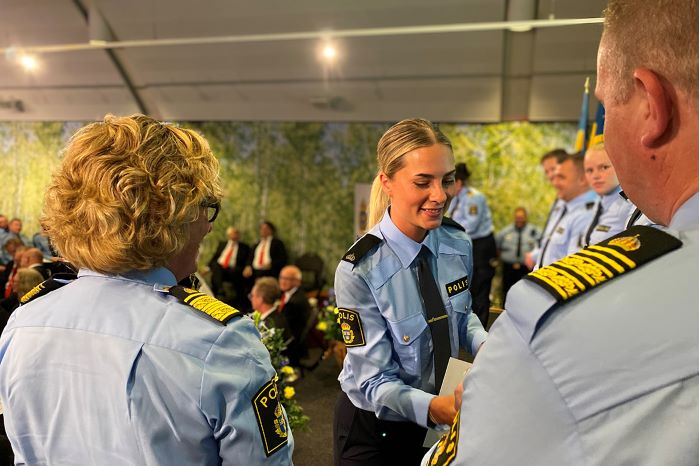 En polisassistent tar emot examensbevis av biträdande regionpolischef Carina Lennquist.