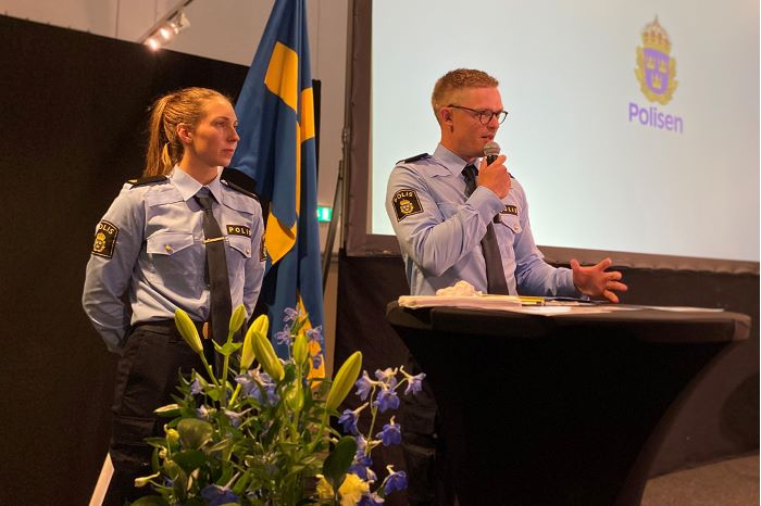 En manlig polisaspirant håller tal under examensceremonin.