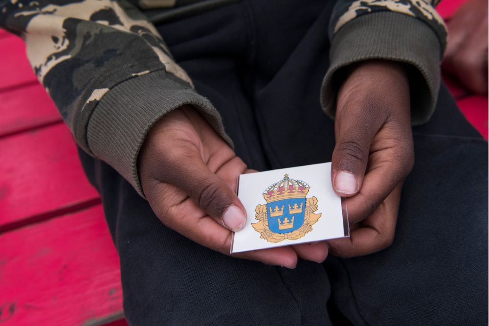 Barn som håller i en polistatuering