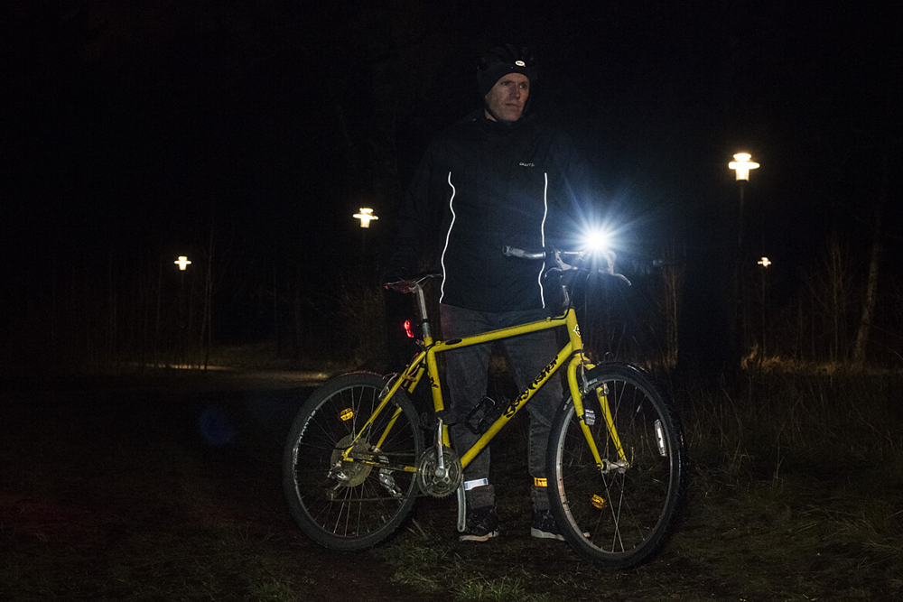 Cykel med vit lampa och vit reflex fram, röd lampa och röd reflex bak samt vita/gula reflexer på sidorna.