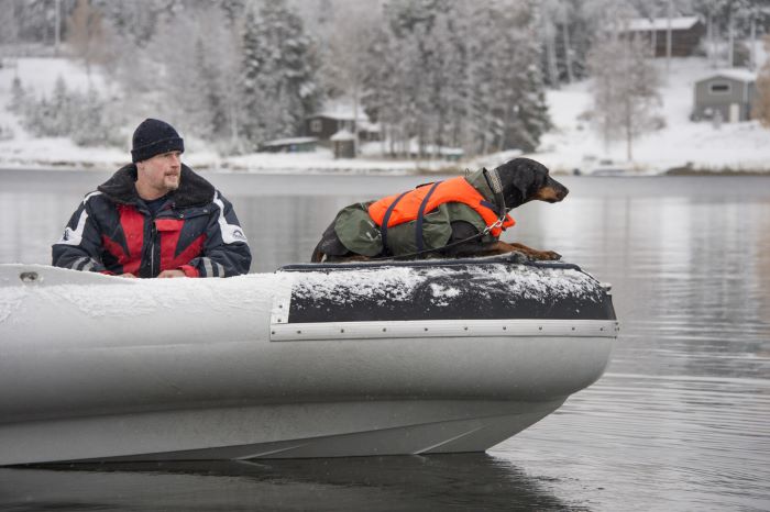 hundförare och hund i båt