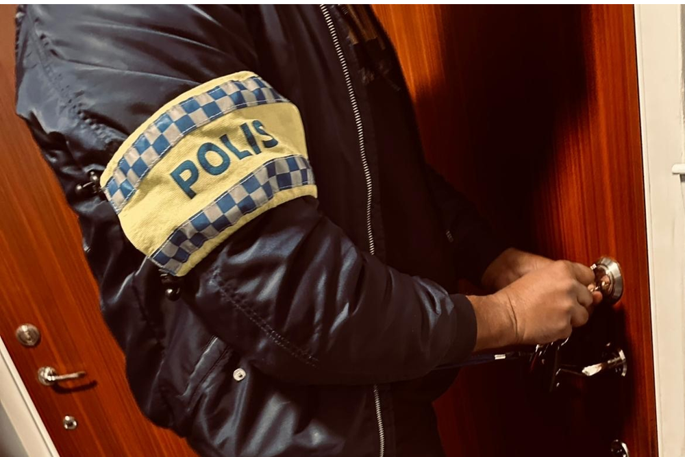 En polis står vid en lägenhetsdörr