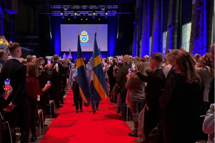 Fotografi som visar när polisassistenterna när de tågar ut ur Värmekyrkan när examensceremonin är slut.