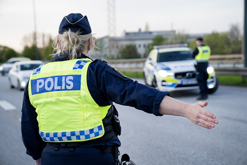 En polis signalerar till en personbil.