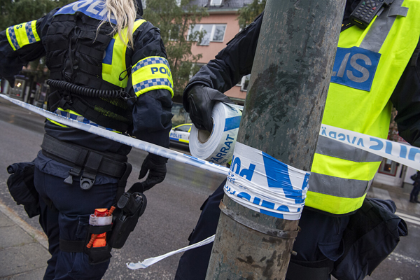 Polisen sätter upp avspärrningsband.