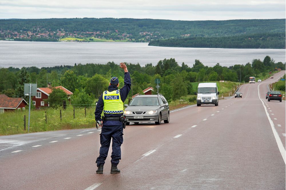 Trafikpolis på en 70-väg i en backig naturskön omgivning