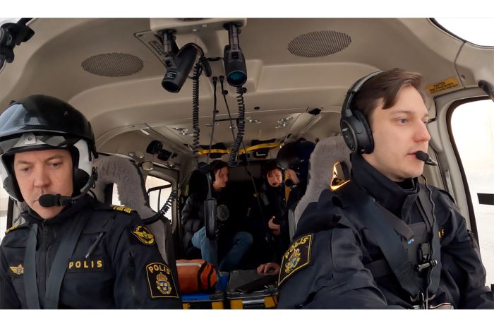 två personer sitter polisklädda inne i helikoptern