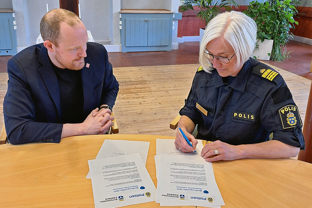 Två personer vid ett bord under signering av gemensamt dokument