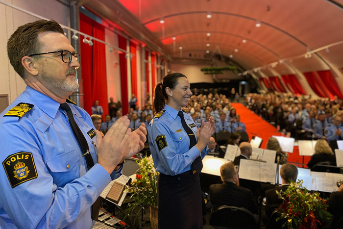 Två polischefer applåderar de nya poliserna. 