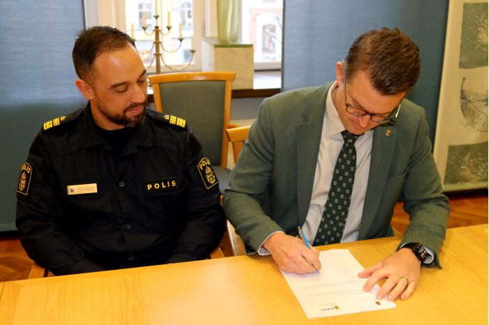 Anders Åhrlin (M) signerar samverkansöverenskommelsen tillsammans med lokalpolisområdeschef Roberto Eid Forest.