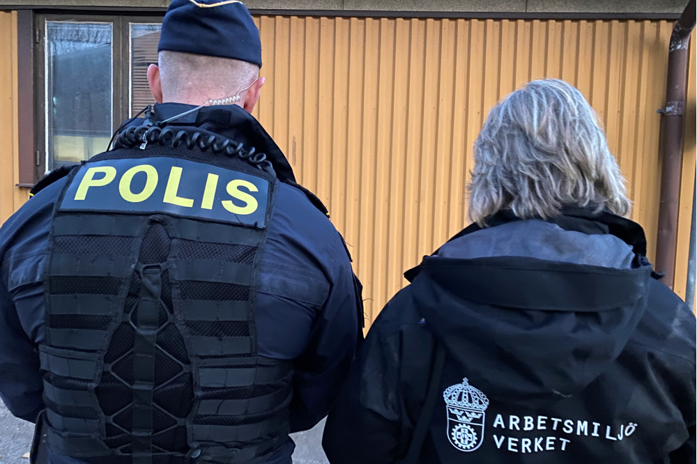 Två ryggar. En polis i uniform bredvid en person som har Arbetsmiljöverket skrivet på jackan.
