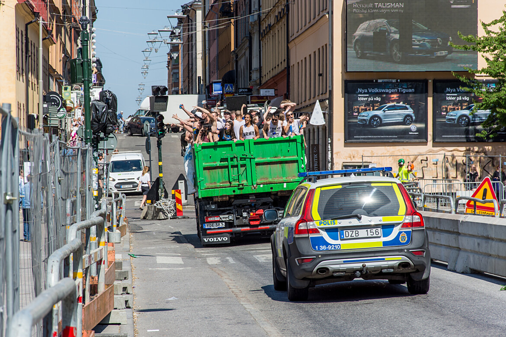 Studenter åker studentflak med en polisbil bakom