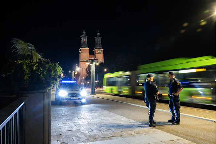 Poliser i Eskilstuna framför en buss i rörelse.