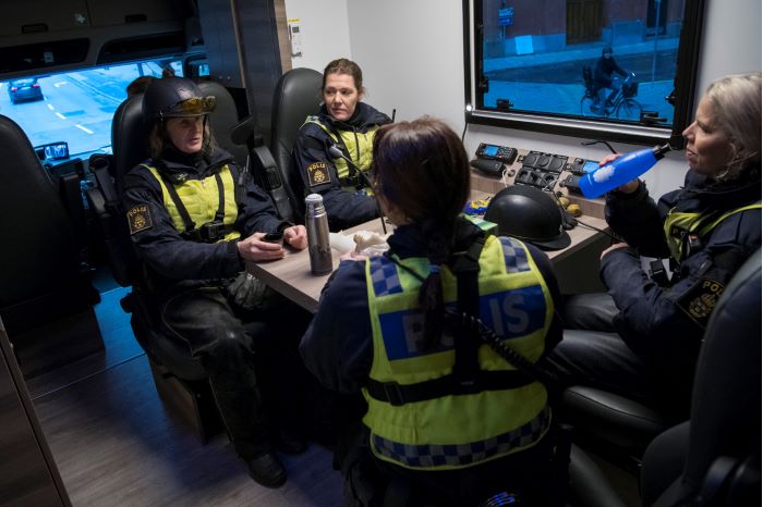Fyra polisryttare sitter vid ett bord i pentryt. Foto.