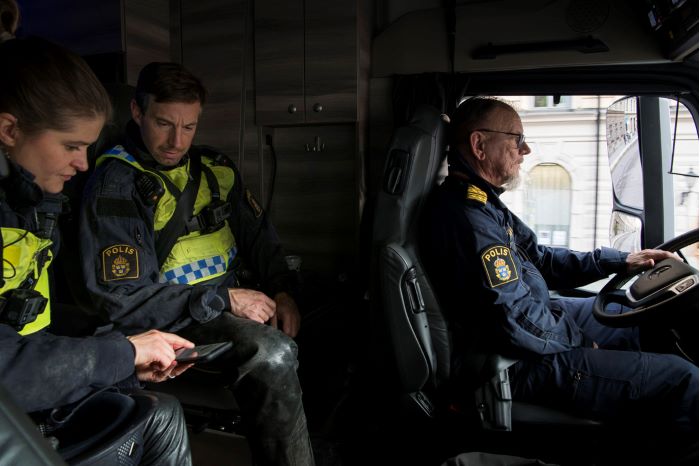 Två polisryttare sitter på passagerarplatserna i lastbilen bakom kommissarie Anders ”Jasse” Jansson. Foto.