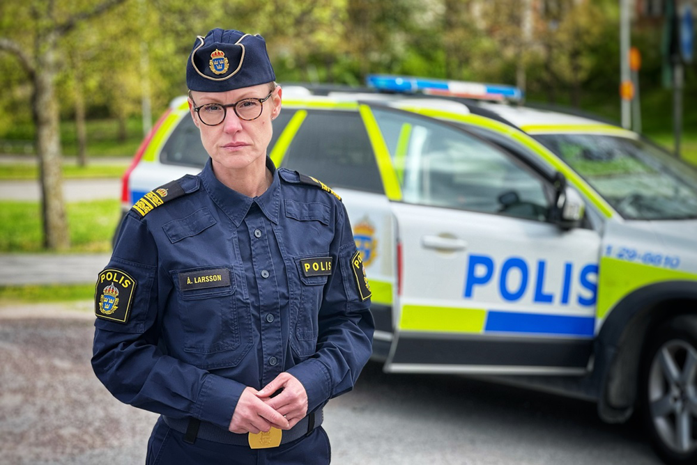 Bild på lokalpolisområdeschef Åsa Larsson framför en polisbil.
