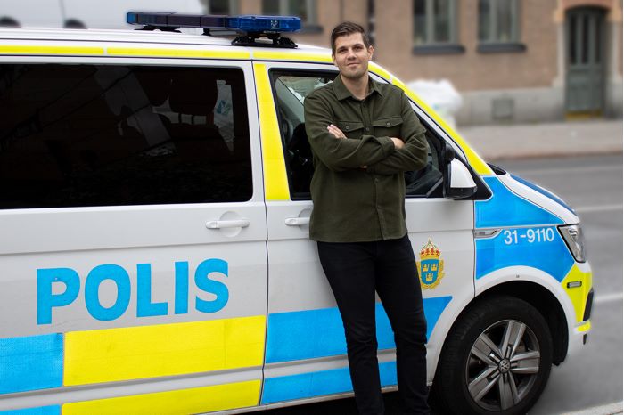 Bild på Emanuel framför en polisbil