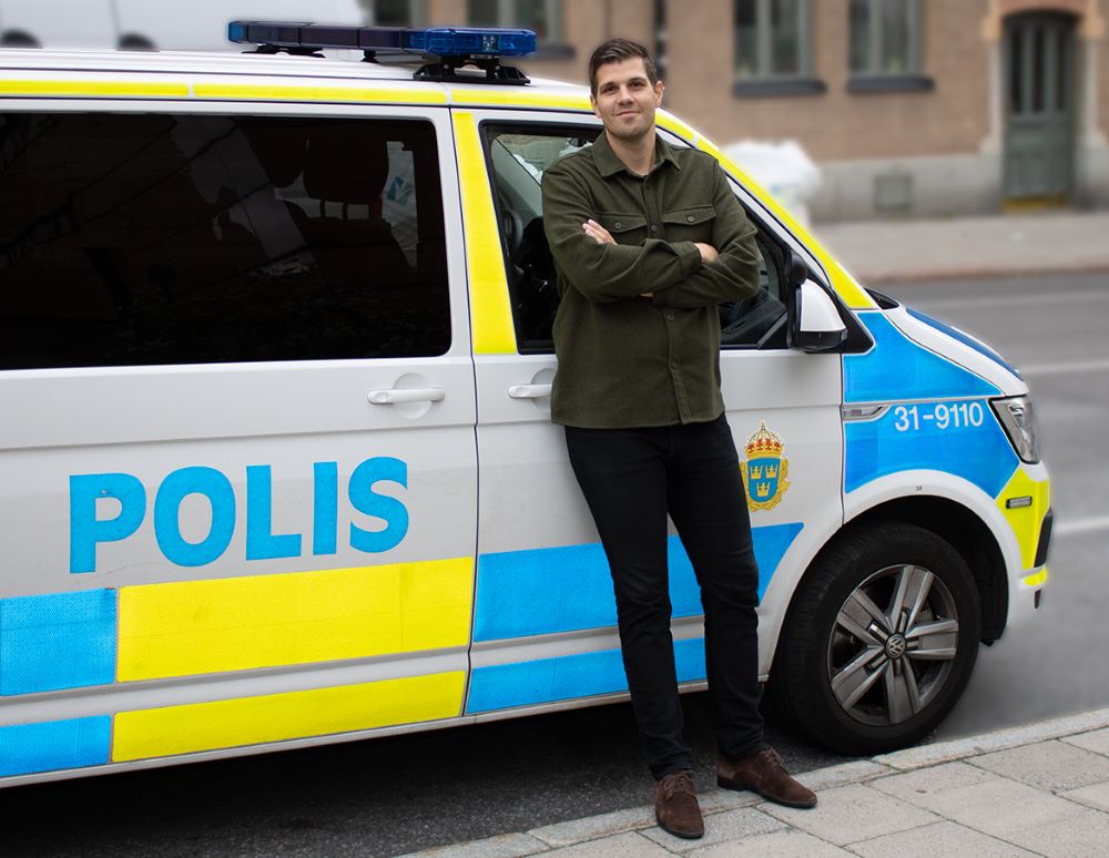 Bild på Emanuel framför en polisbil