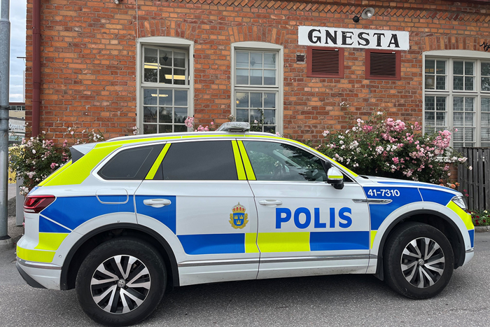 Polisbil framför en byggnad med en skylt med texten "Gnesta".