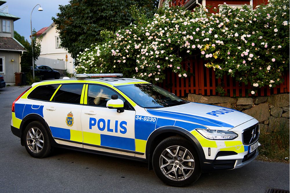 Foto på en polisbil som står bland blommor på Vaxholm.