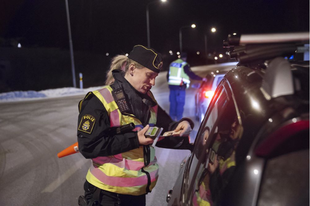 Polis som står vid en bil för att göra en nykterhetskontroll.