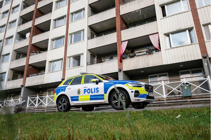 Polisbil utanför bostadshus i Årby.