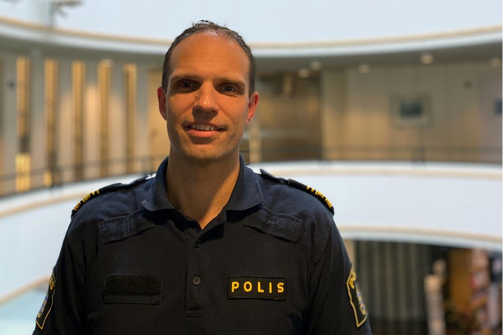 Fotografi av Rickard Eriksson i polisuniform inomhus.