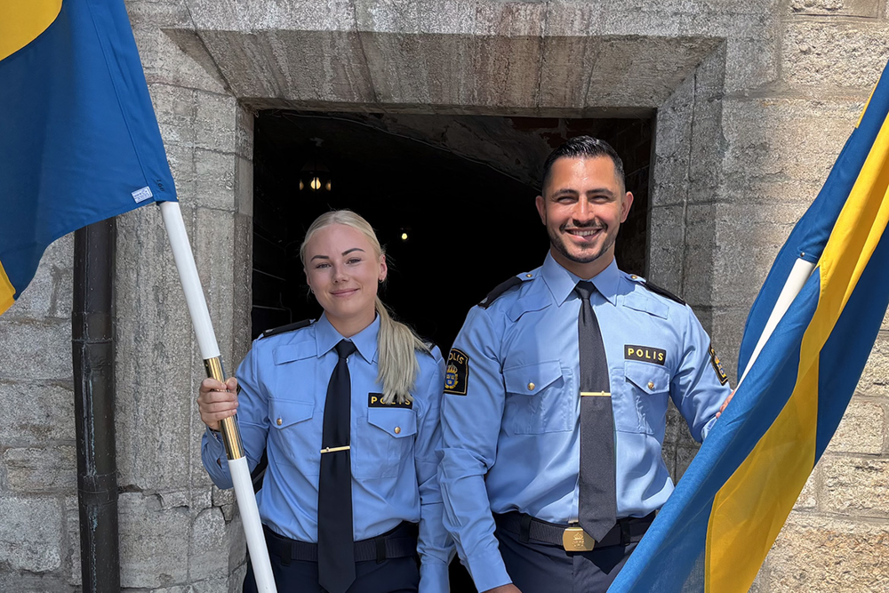 Ett fotografi som visar en kvinnlig och en manlig polisaspirant som är fanbärare.