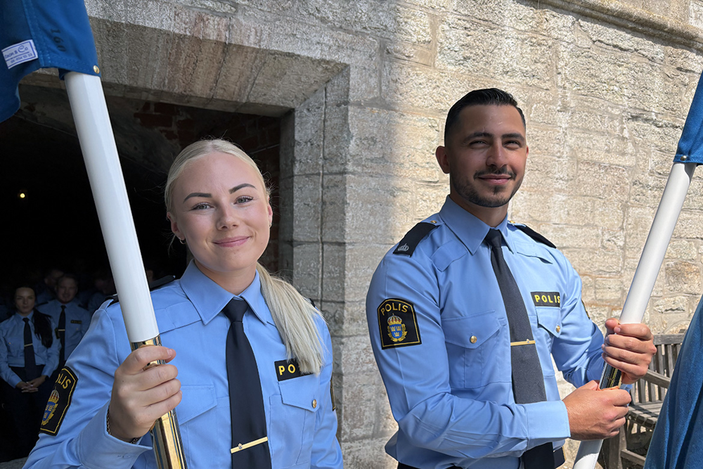 Ett fotografi som visar en kvinnlig och en manlig polisaspirant som är fanbärare.