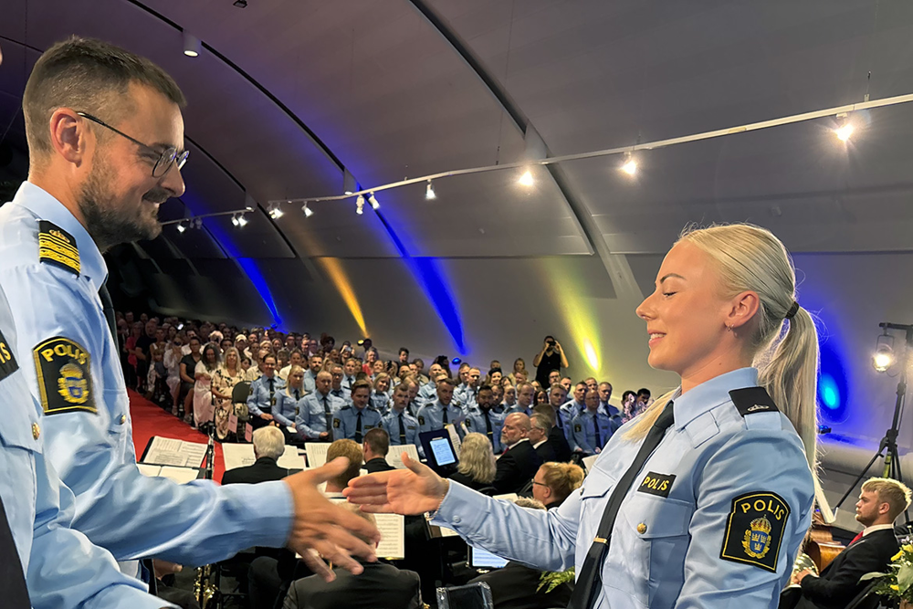 Ett fotografi som visar när en av polisaspiranterna tar emot sitt examensbevis.
