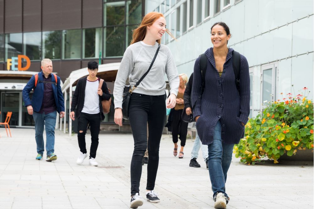 Studenter utanför universitetsbyggnad.