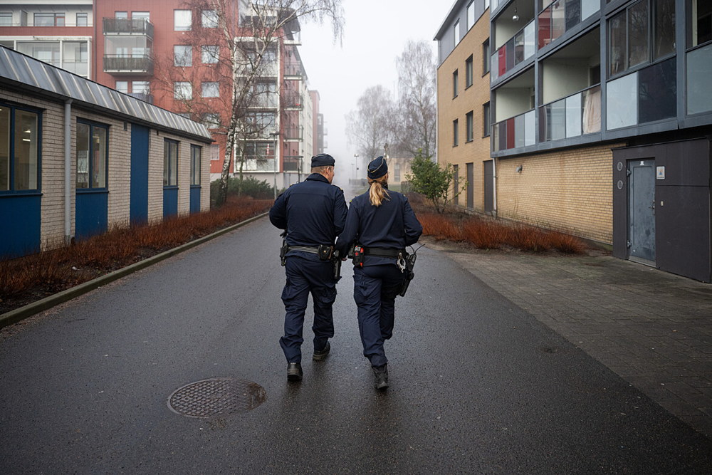 Två poliser på avstånd på en gata.