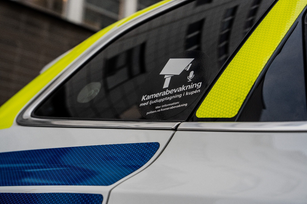 Sidan på en polisbil med ett klistermärke som visar att det finns kamerabevakning.