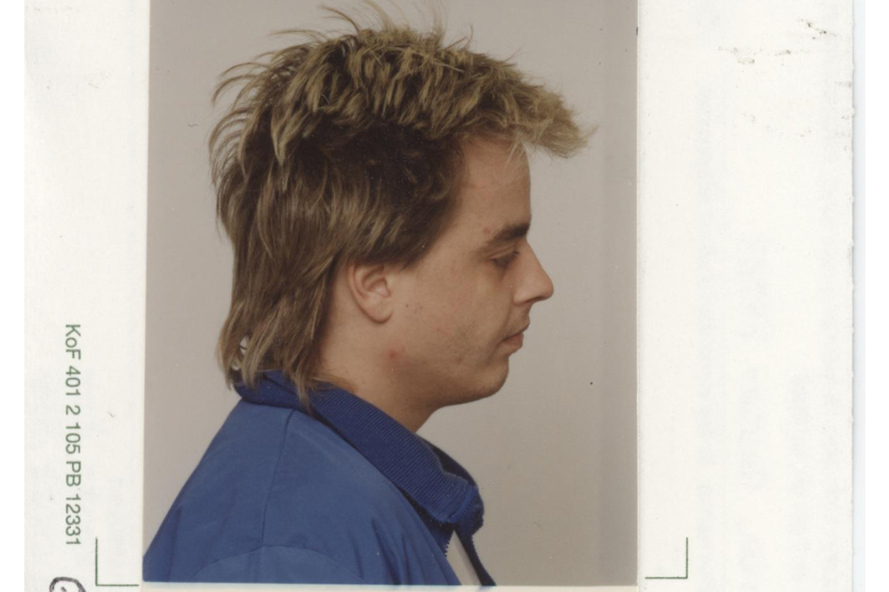 Foto på Peter Engström i profil. På bilden har han längre hår (hockeyfrilla), blont hår men håret intill hårbotten är något mörkare. Han har på sig en vit t-shirt och en mellanblå jacka.