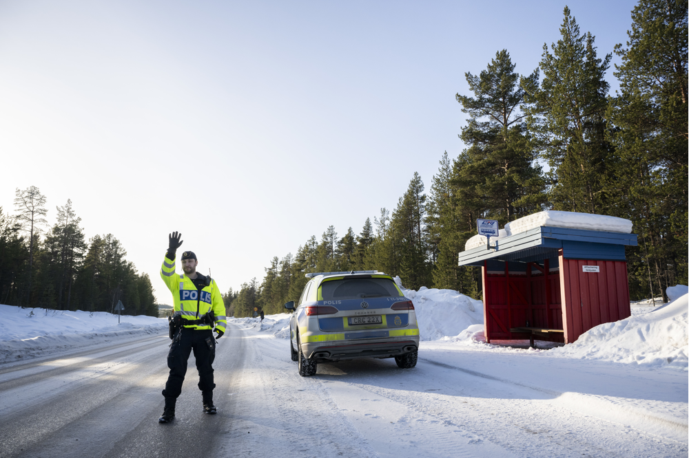 Polis på vintrig väg som håller kontroll.