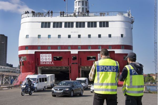 Two policemen in front of a dock and a big ferry.