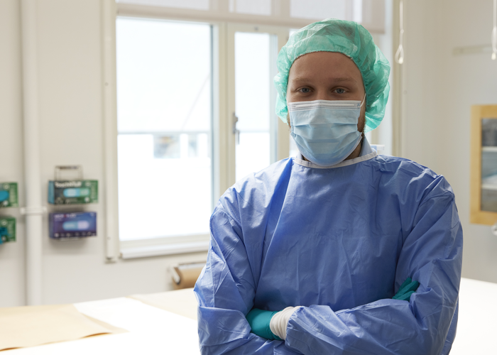 person klädd i labbkläder står i en laboratoriemiljö