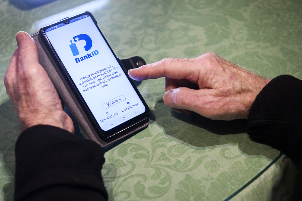 Hand med mobil som har BankId öppet