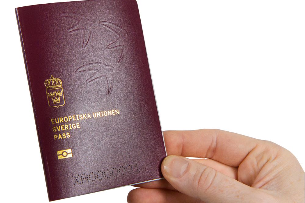 Hand som håller i ett pass.