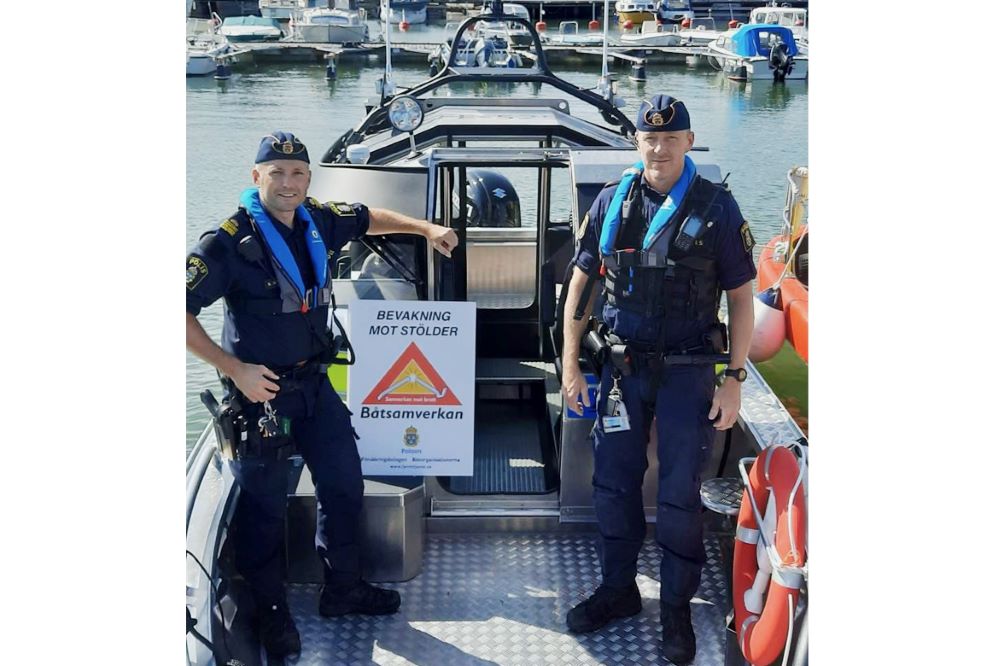 Sjöpoliserna Robert Sverlert och Petter Lindblad ståendes på den silvergrå polisbåten..