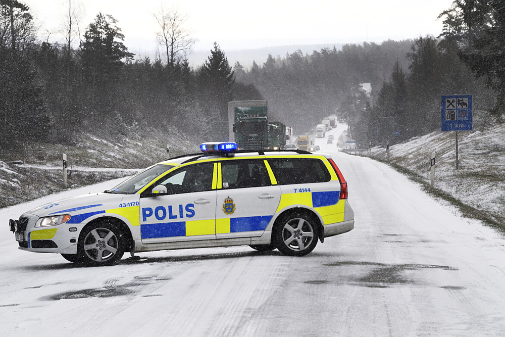 Ett fotografi som visar en polisbil som står tvärs över en snöig väg