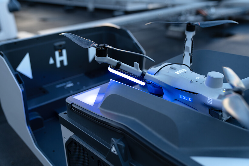 Drönare med texten polis på sidan med blått ljus.
