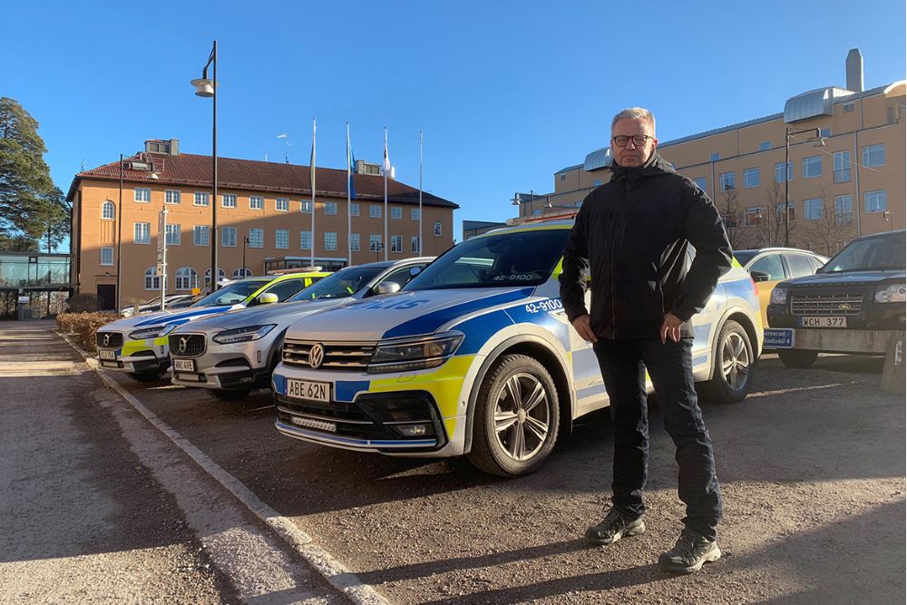 Polisanställd står utanför en polisstation. Foto.