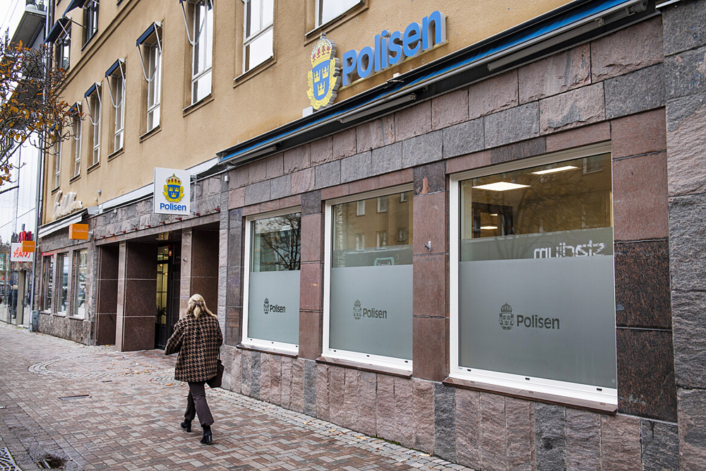 Bild på en gata i centrala Karlstad där en skylt som det står Polisen på sitter uppsatt på fasaden. Där är ingången till polisens servicekontor.