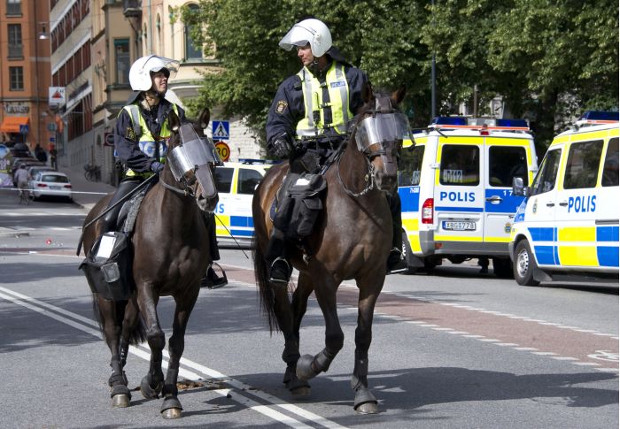 Två poliser till häst utrustade för kravall.