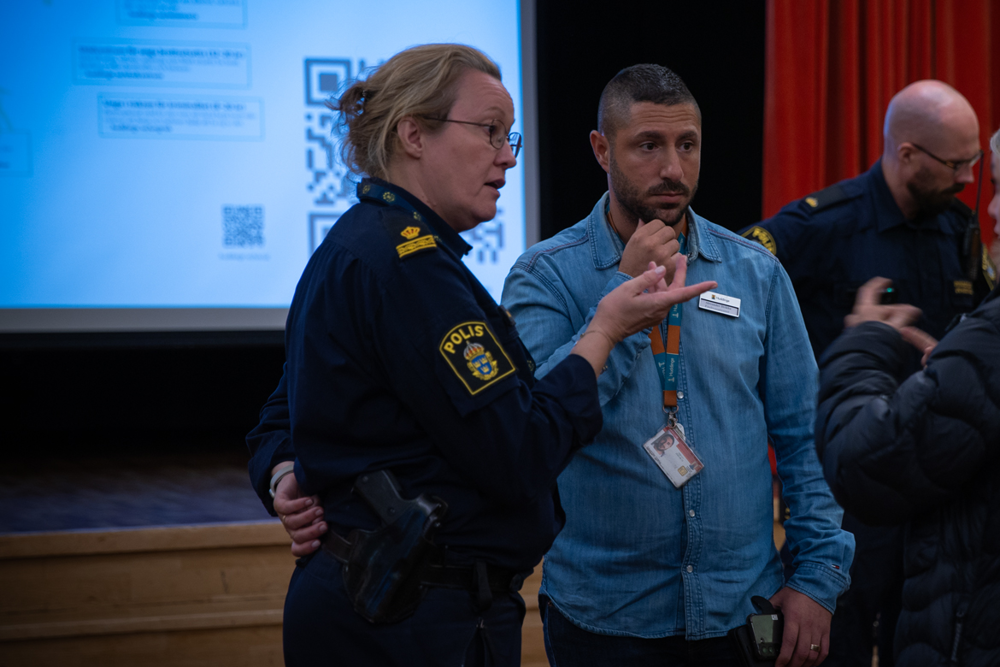 Foto på Anna Schelin och Alexander Drikha som står och pratar med medborgare efter informationskvällen.
