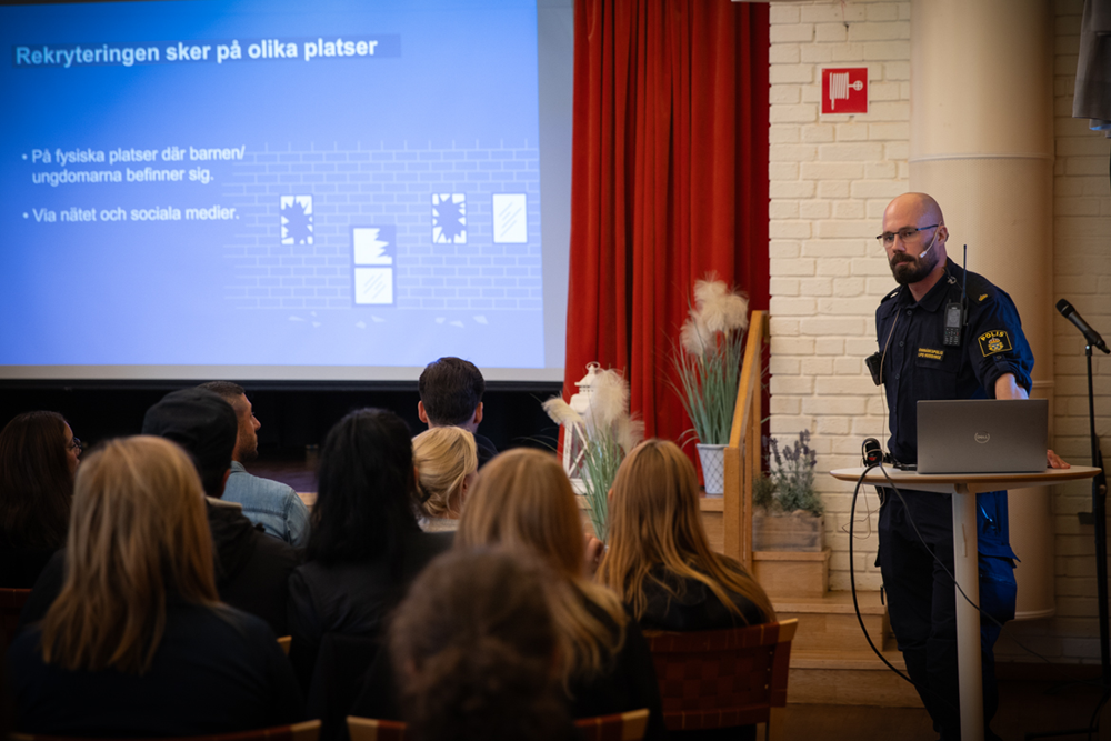 Foto på Anton Lindberg Lundmark som pratar till en powerpoint framför en publik.