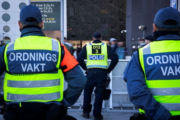 Ordningsvakter och polis utanför arena i Stockholm.
